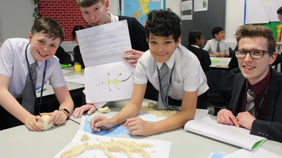 Students smiling and showing off their work