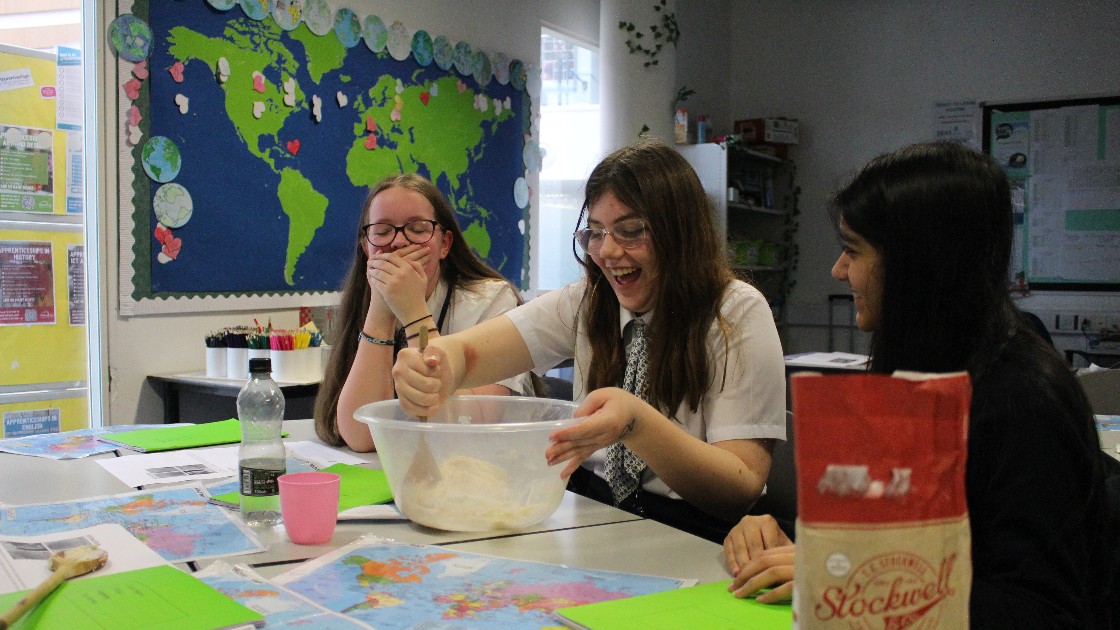 Mixing a bowl of dough whilst friends are laughing