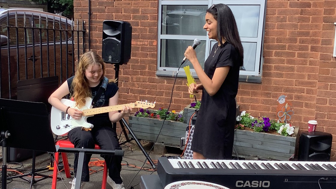 Two students perform; a guitarist and a vocalist