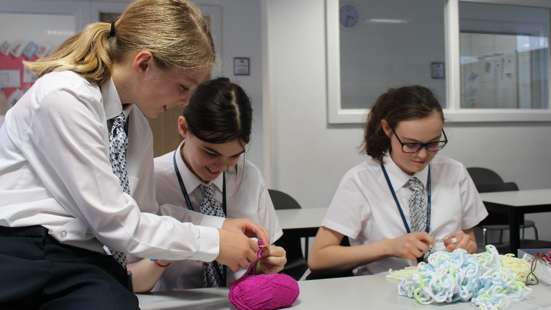 Students enjoying and helping each other with their knitting