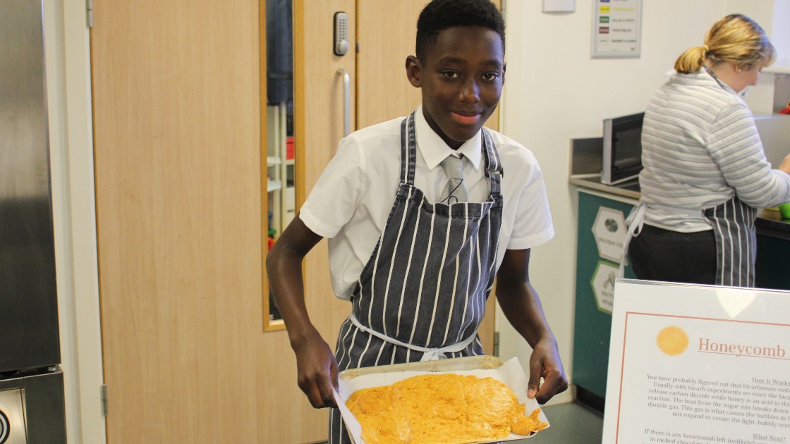 A student with a tray of cooked honeycomb.