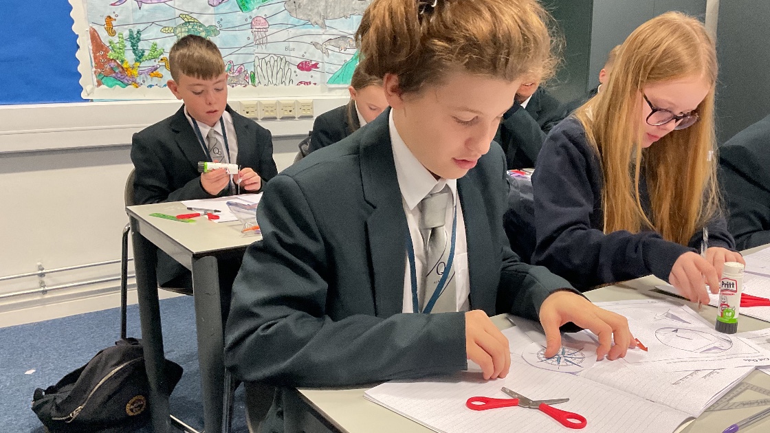 Children gluing and sticking a compass