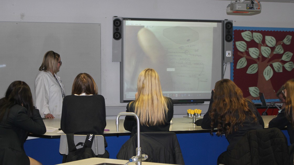 A teacher modelling a good answer on the whiteboard