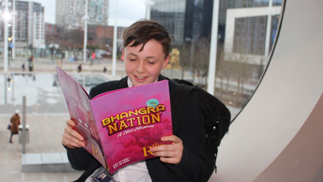 A student reads the programme in the window of the theatre.