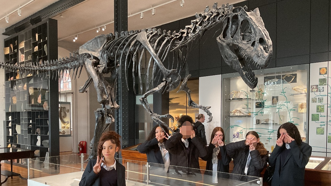 Students standing next to a fossil.