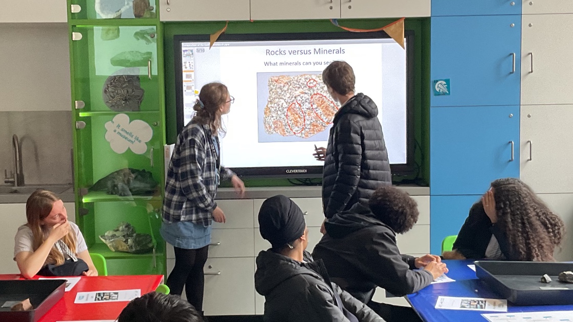 Students looking at the board as another student points