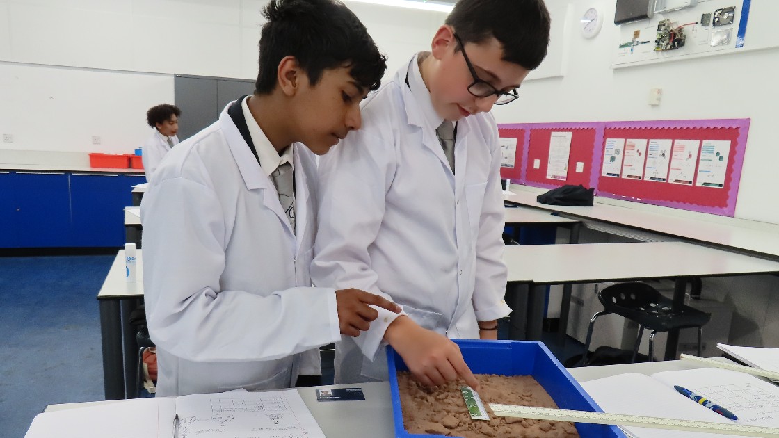 Students measuring the size of the crater.