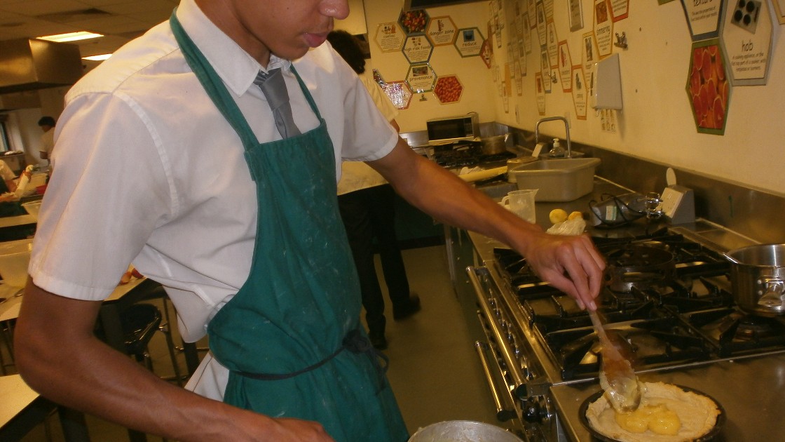 One of the students adding his lemon curd into the pastry.