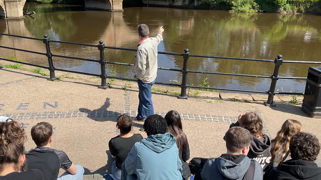 A teacher showing the class features of the river
