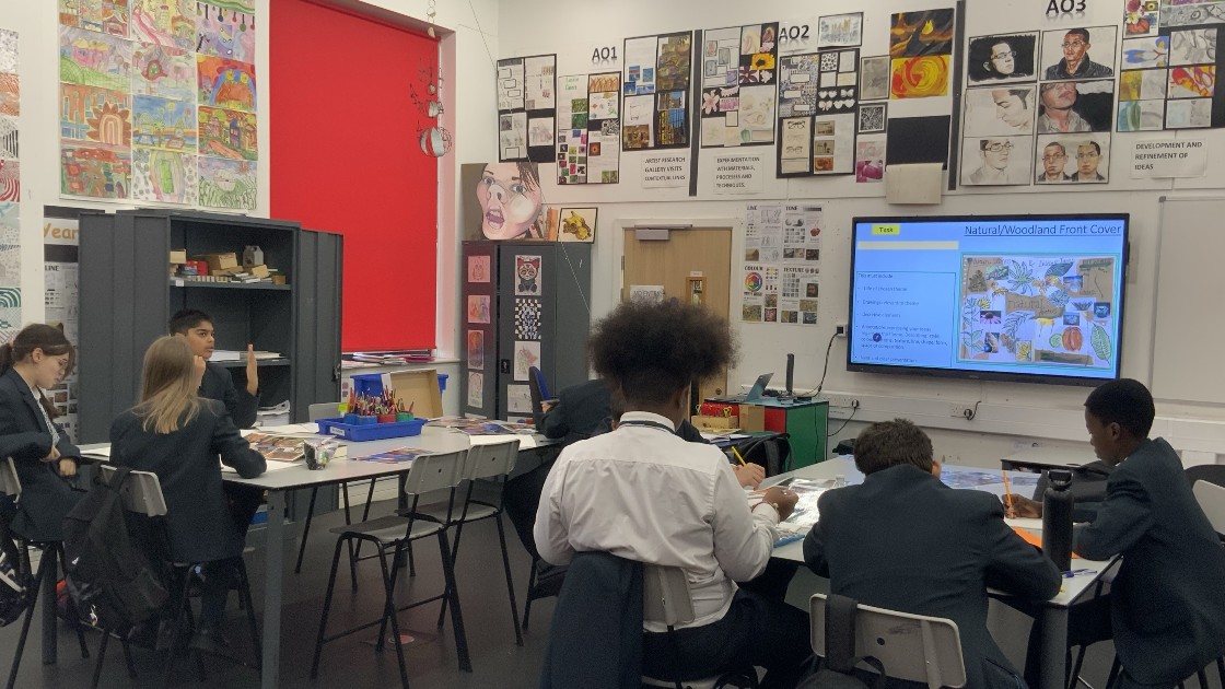 Students in an art classroom working on projects, with artwork displayed on walls