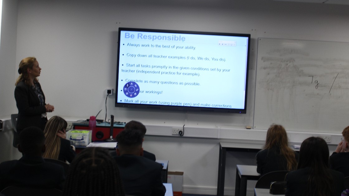 Teacher presenting a slide on being responsible to Year 7 students in a classroom
