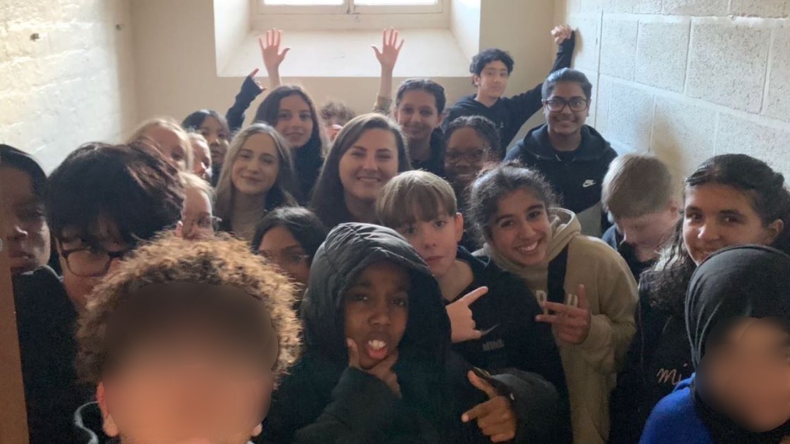 A group of students posing together in a prison cell.
