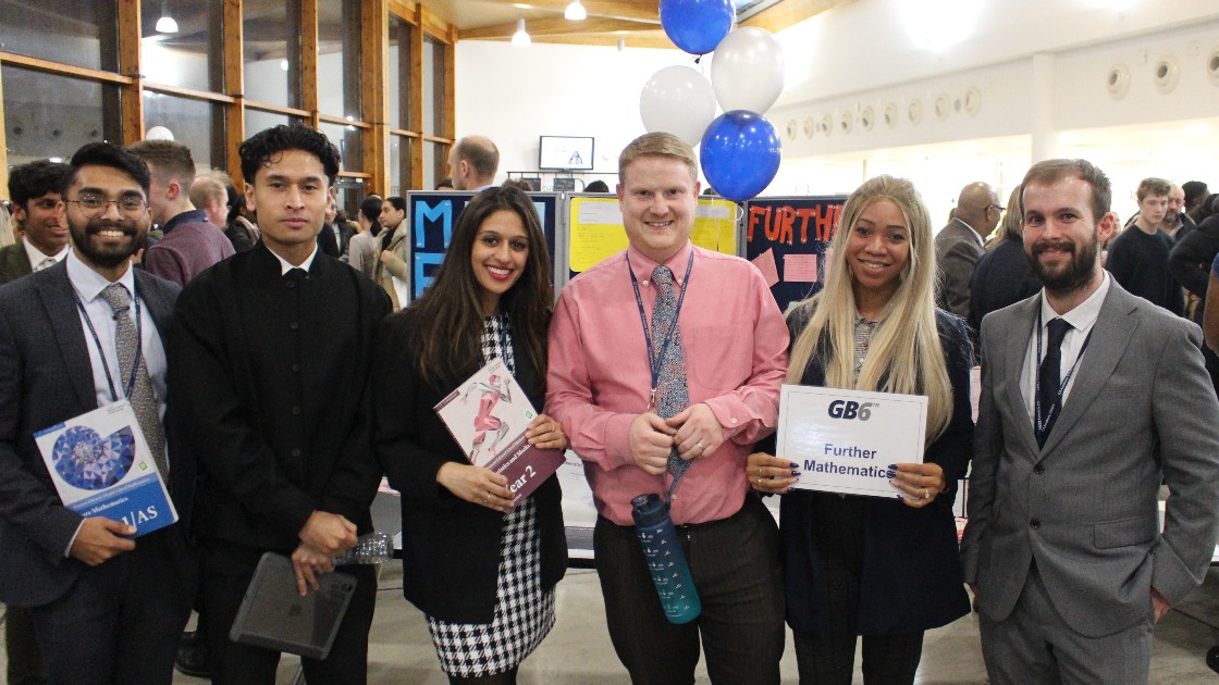 Maths teachers at Sixth Form Open Evening, standing in front of display boards