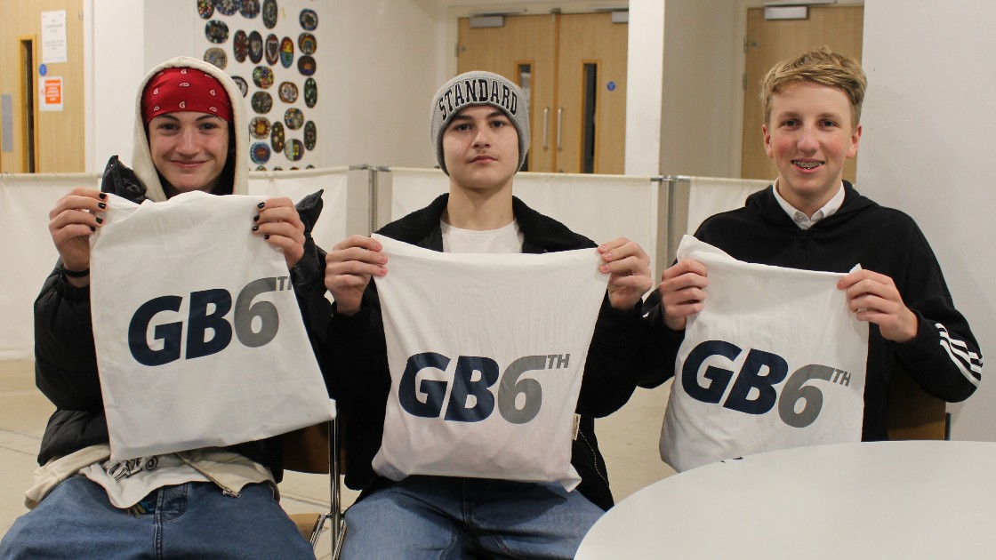 Three students holding GB6th-branded bags at Sixth Form Open Evening
