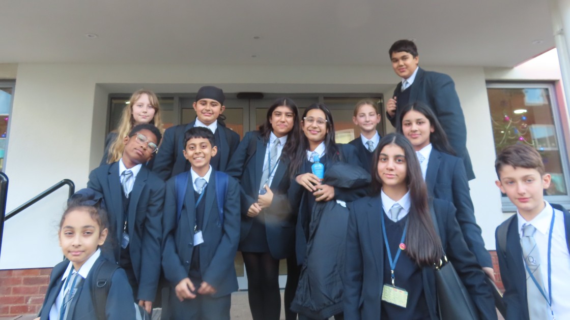 A group of students in school uniforms standing together outside a building