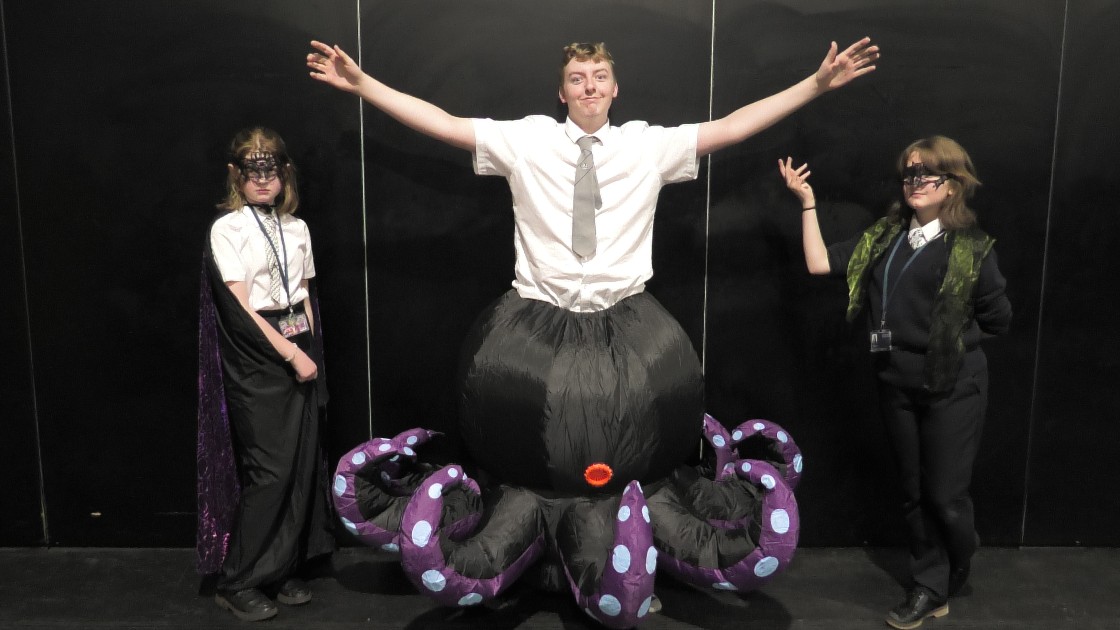 Three students in costume for a pantomime, including one dressed as an octopus