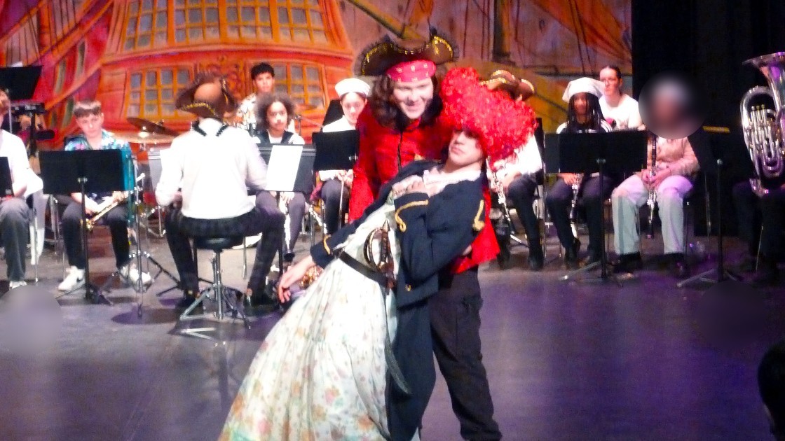 Students performing Treasure Island pantomime with a band in the background