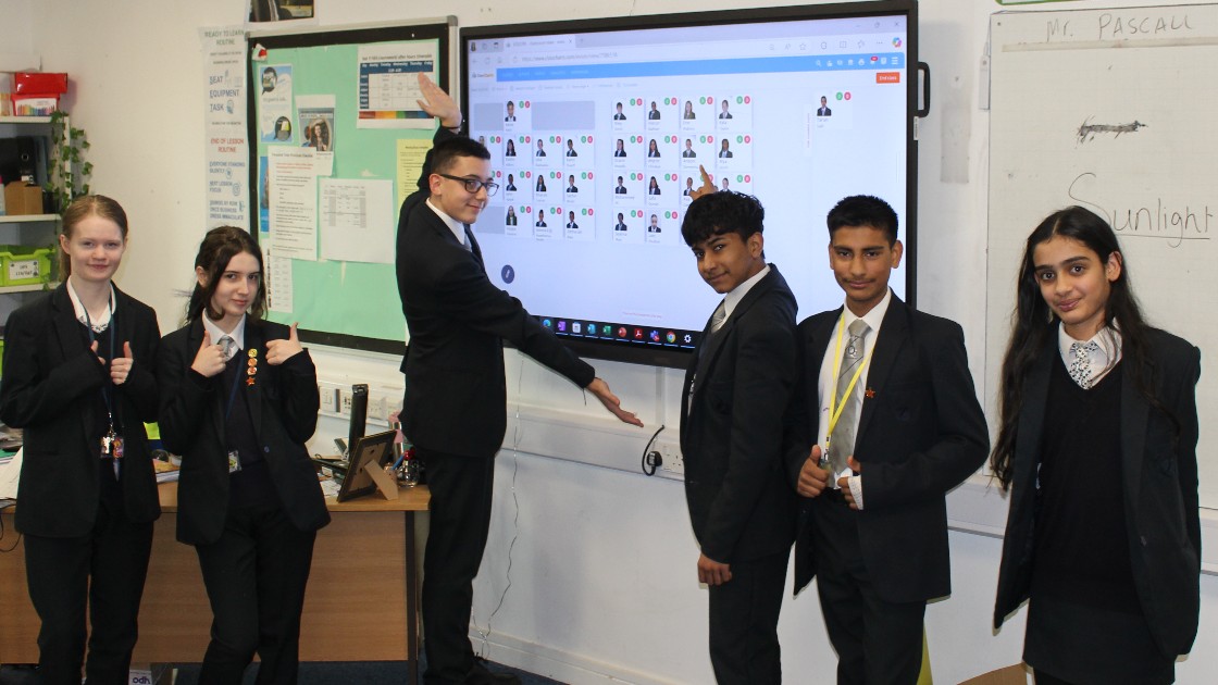 Students in a classroom presenting a digital display on a screen