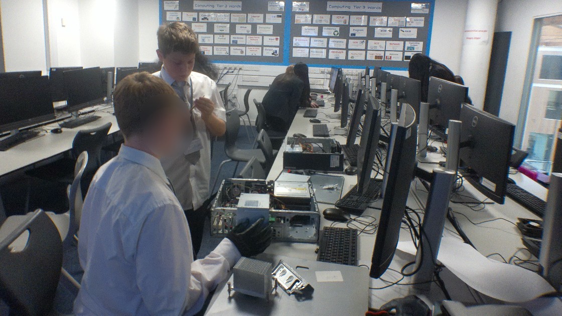 Students in a computing classroom working on computer hardware