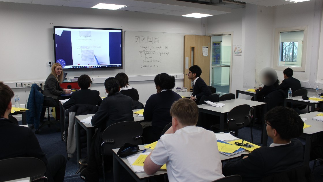A teacher conducting a statistics lesson with students seated at desks