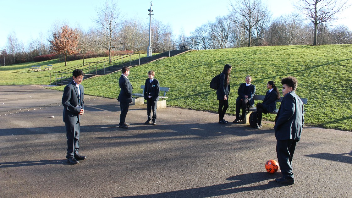 Students playing and talking outdoors on a sunny day