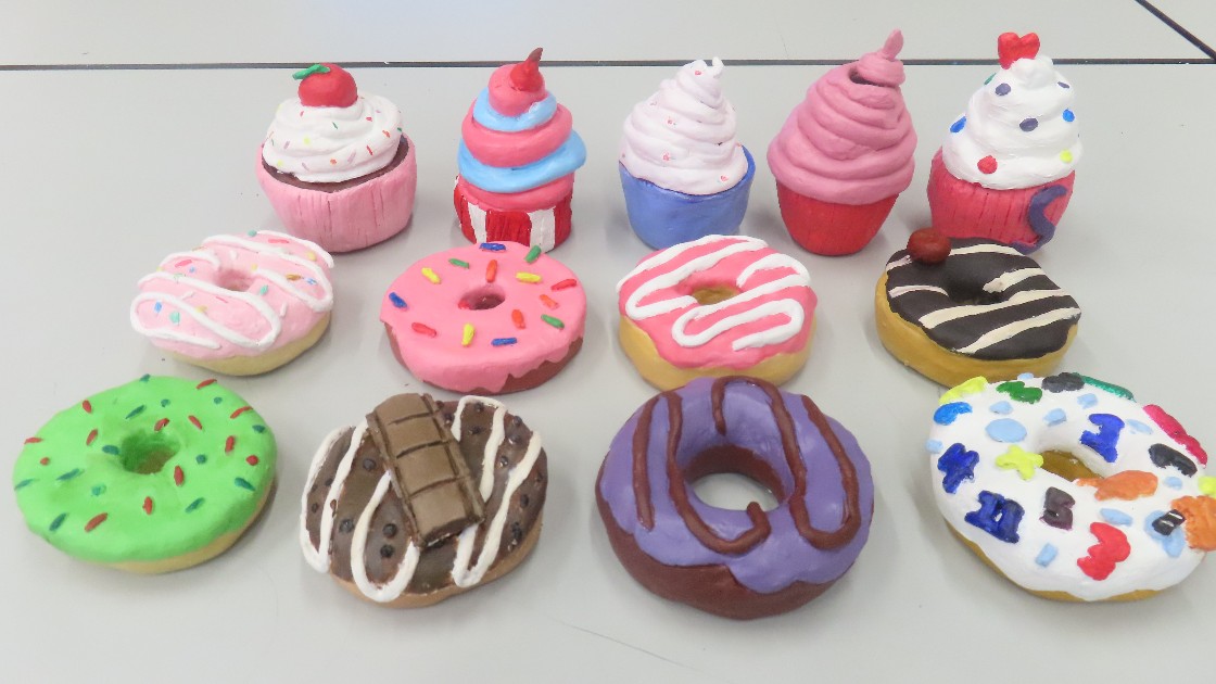 Clay models of doughnuts and cupcakes, painted in bright colours