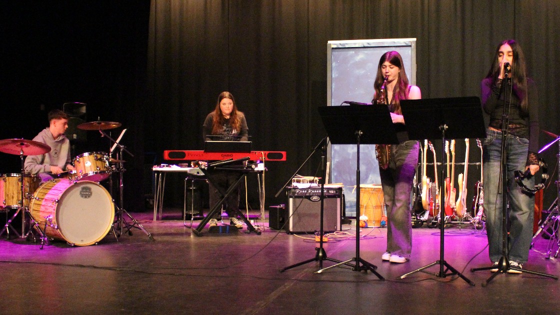 Students performing on stage with musical instruments during Battle of the Bands
