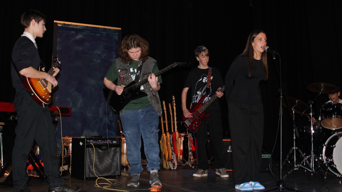 Students performing on stage with musical instruments during Battle of the Bands