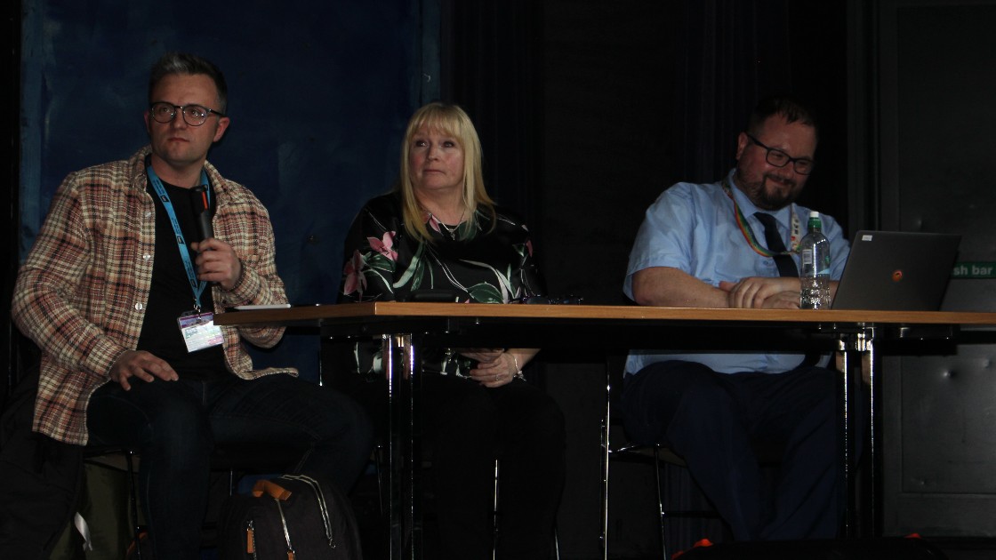 Three judges seated at a table during a Battle of the Bands event