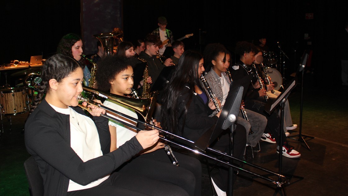 Students playing musical instruments on stage during a performance