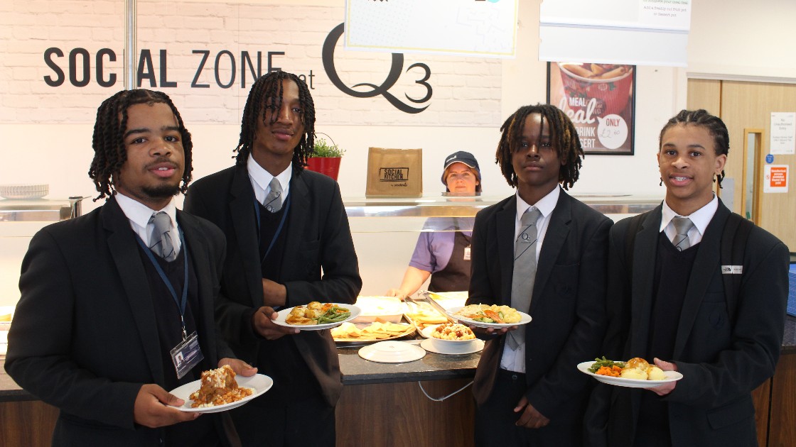Four students holding plates of healthy food