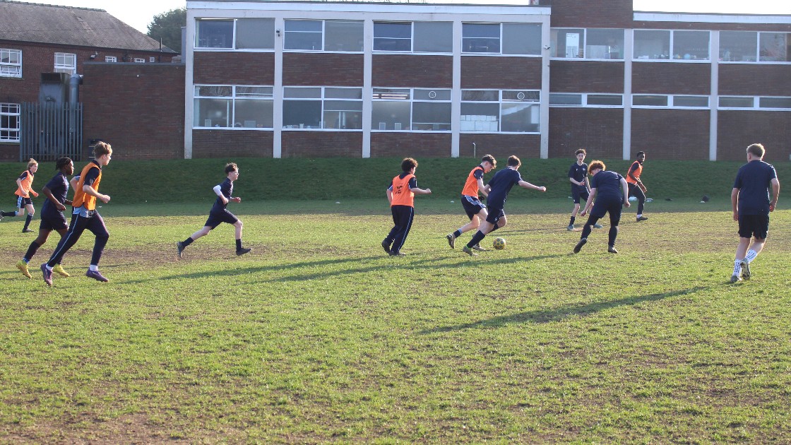 Year 9 boys playing football on a football pitch