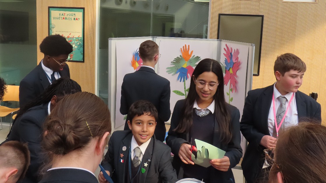Students in school uniforms participating in an anti-bullying event, creating positive affirmation flower artwork.