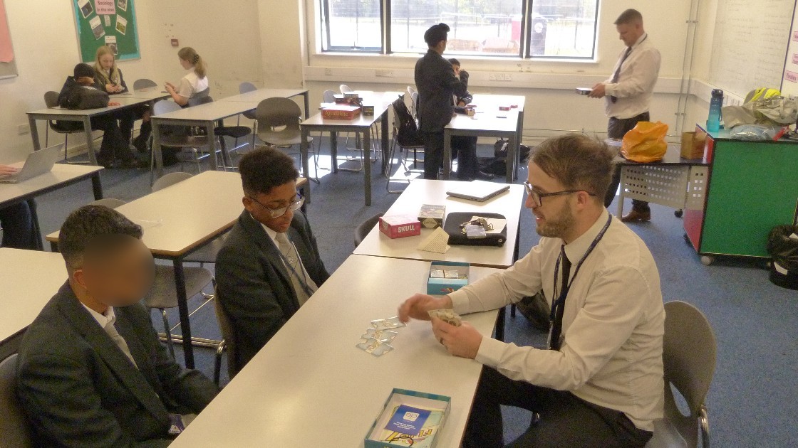 Teacher and students playing a board game in a classroom
