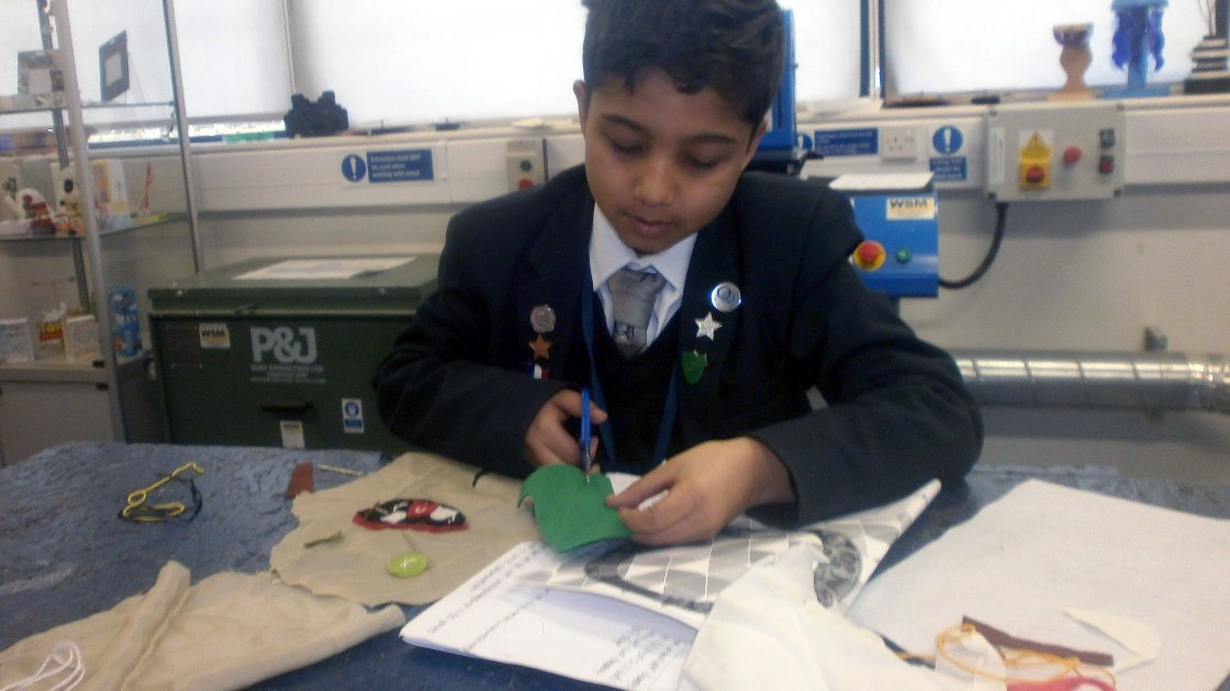 Student cutting fabric with scissors during a DT lesson