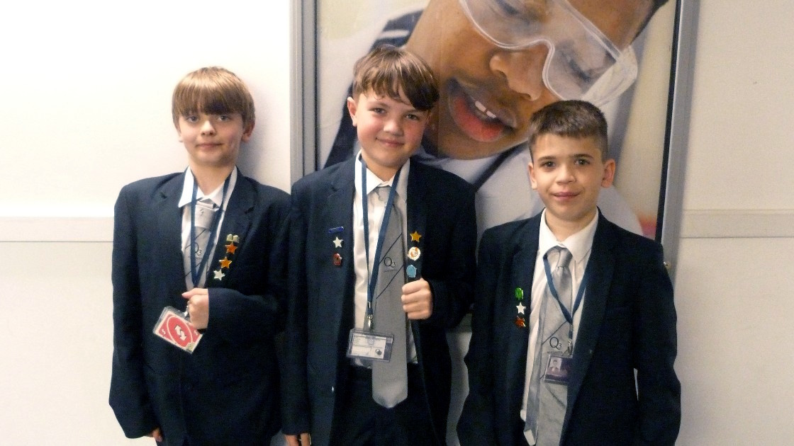 Three students in school uniform wearing award badges