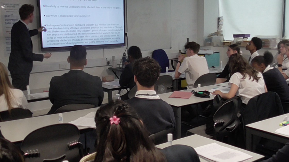 Teacher presenting a lesson on Shakespeare to students in a classroom