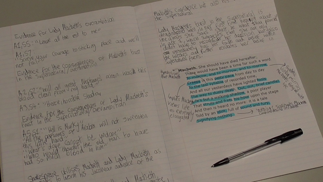 Open exercise book with handwritten English notes and a highlighted Macbeth passage, with a pen beside it