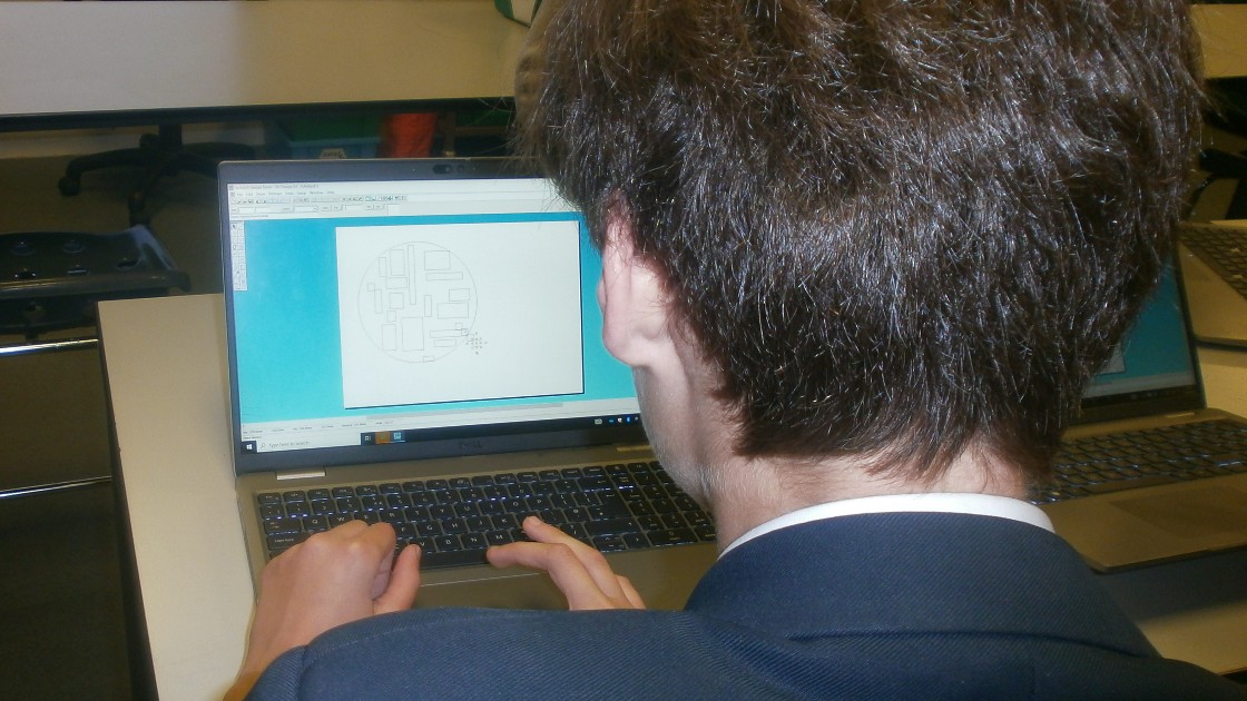 Student working on a computer aided design software to create a clock.