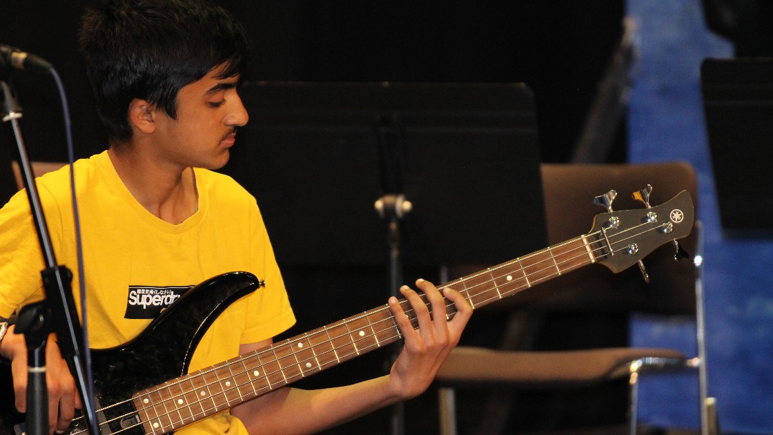 Student playing an electric bass guitar during Summer Fest Day One